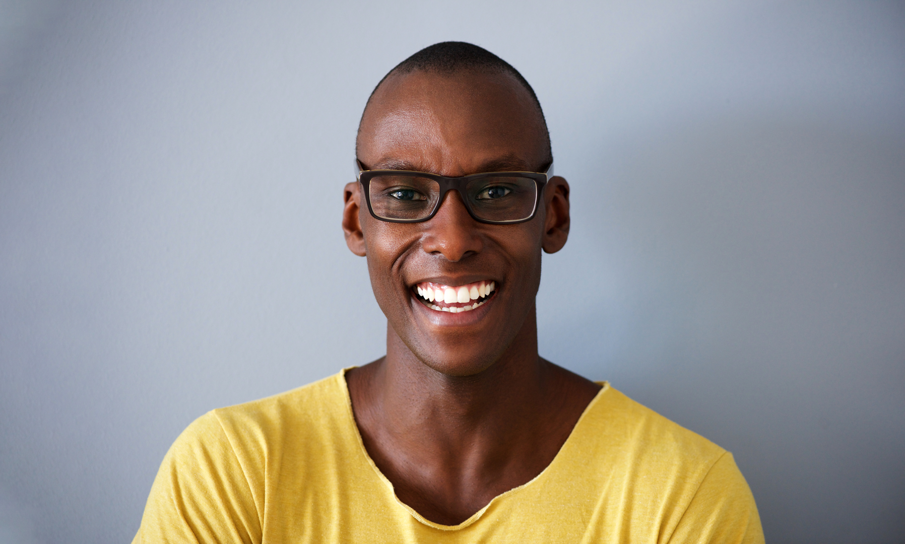 close-up-smiling-african-american-man-against-gray-2021-08-27-14-14-23-utc